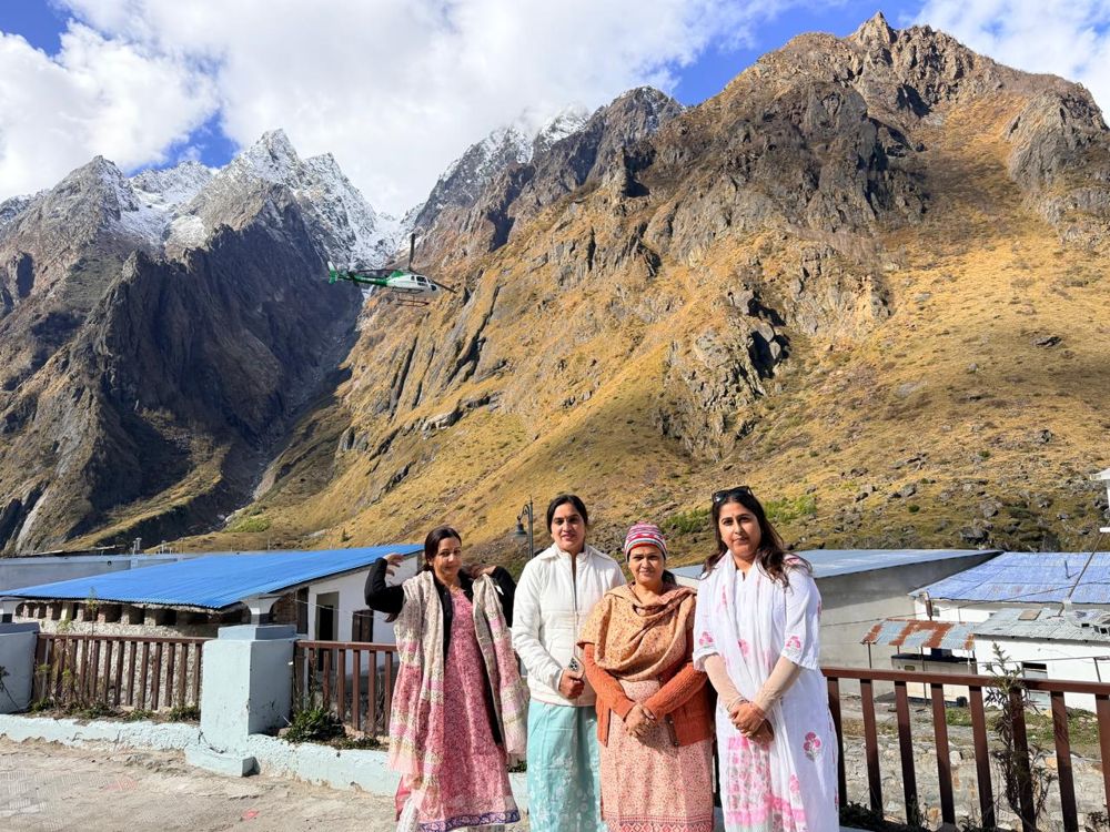 Travellers below the Himalayas with a helicopter overhead