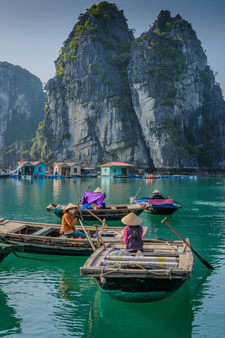 Rowing boats among limestone cliffs, Halong Bay