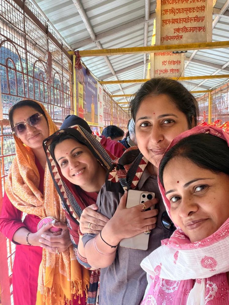 Friends smiling in a temple queue