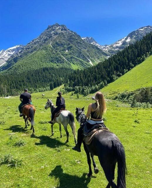 Horse riding through green mountain valleys near Almaty