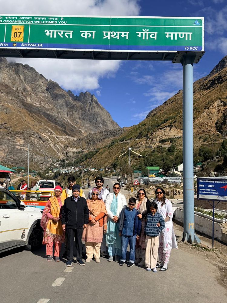 Family group under the Mana village welcome sign