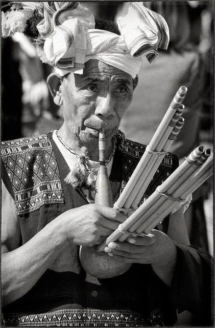 Elder playing a traditional gourd pipe