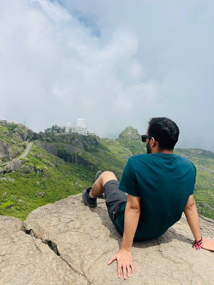 Traveller resting on the rocks at Guru Shikhar, Mount Abu